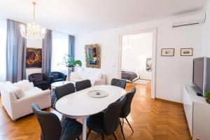 a living room with a white table and chairs at Relax Centar Apartment in Podgorica