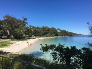 uma vista para uma praia com pessoas na água em Broughton Views em Corlette