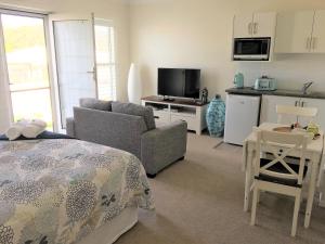 
a hotel room with a television and a bed at Broughton Views in Corlette
