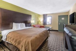 a hotel room with a large bed and a couch at Quality Inn and Suites in Franklin