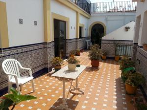 patio ze stołem i krzesłem w budynku w obiekcie Hostal Málaga w mieście Arcos de la Frontera