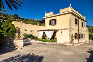 un edificio con molte piante di fronte di Valle Degli Dei AgriResort a Noto