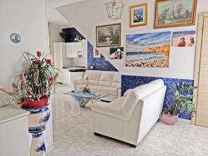 una sala de estar con muebles blancos y paredes azules y blancas. en Capitan Shonny, en Portoscuso