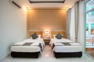 白马市Sangkahak Mith Hotel的一间房间里有两张床的卧室