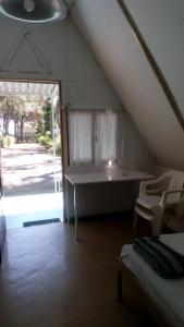een zolderkamer met een tafel en een raam bij Olympos Beach in Plaka Litochorou