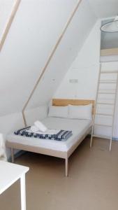 Cama blanca en habitación con escalera en Olympos Beach, en Plaka Litóchoro