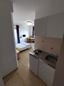 a kitchen with a stove and a sink in a room at Villa Ilona in Primošten