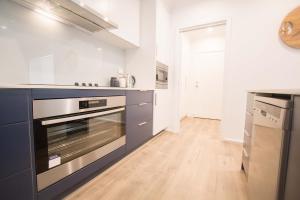 泰勒姆班的住宿－Contemporary ‘Esprit’ with river reserve access，厨房配有蓝色橱柜和炉灶烤箱。