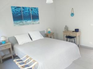 a bedroom with a large white bed with two tables at Le Golfe in Figari