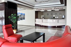 a waiting room with red chairs and a table at Voznesenskaya Hotel in Ivanovo