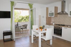 a kitchen with a table and chairs and a dining room at Apartments St.Anthony in Korčula