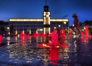a red fire hydrant in the middle of a water fountain at Nocleg 62 Koszalin in Koszalin