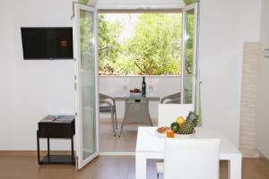 a living room with a table and a sliding glass door at Apartments St.Anthony in Korčula