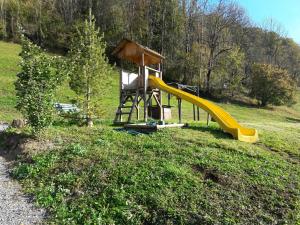 einen Spielplatz mit Rutsche auf dem Feld in der Unterkunft Klausberg-Hütte in Bezau