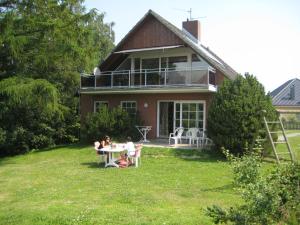 two people sitting at a table in front of a house at Ferienhaus I Weitblick in Grömitz