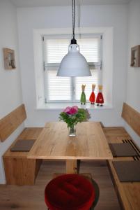 a dining room table with a vase of flowers on it at hezelhof´s Hexenhäuschen in Dinkelsbühl