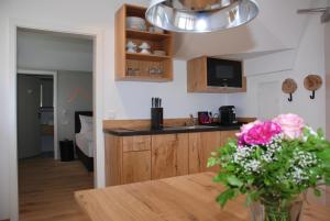 a kitchen with a table and a vase of flowers at hezelhof´s Hexenhäuschen in Dinkelsbühl