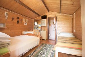 a bedroom with two beds in a wooden room at U Synowców in Polańczyk