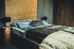 a bedroom with a large bed with a wooden wall at Rzepiska Hills in Rzepiska