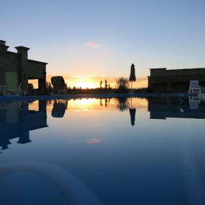 a swimming pool with the sunset in the background at Finca La Carmelita in San Rafael