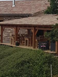 einem Holzpavillon mit Stühlen und Tischen auf einem Haus in der Unterkunft Gite de prejeurin in Échalas