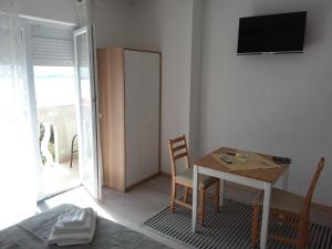 a dining room with a table and a television on the wall at Villa Marin in Pag