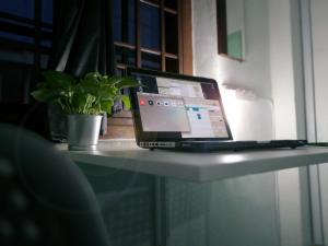 a laptop computer sitting on a table with a plant at Edm Space in Ipoh