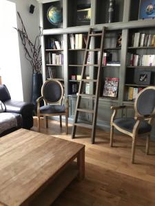 a living room with two chairs and a book shelf at Villa Camélia in Bayeux