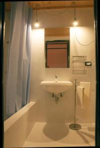 a white bathroom with a sink and a mirror at BORGO PETELIA, Casa Mannarino, suite Lucrezia in Strongoli