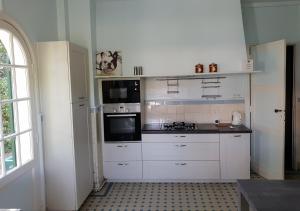 a kitchen with white cabinets and a stove top oven at La Villa Fuberia - Seafront Bassin d'Arcachon in Pyla-sur-Mer +34 photos