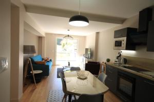 uma cozinha e uma sala de estar com uma mesa num quarto em B2 - Résidence La Montille em Le Mont-Dore