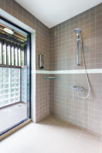 ein Bad mit einer Dusche und einem Fenster in der Unterkunft The River Resort in Champasak