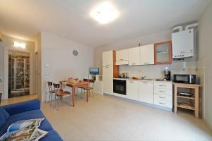 een keuken en een woonkamer met een blauwe bank en een tafel bij Appartamento Alla Fonte in Salò