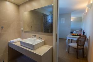 a bathroom with a sink and a mirror and a table at THALASSA VIEW RESIDENCE in Argostoli