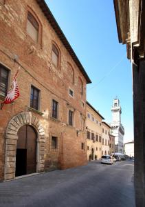 an old brick building with an american flag on it at Appartamenti Bellarmino in Montepulciano