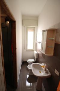 bagno con lavandino, servizi igienici e finestra di Stanza Matrimoniale con bagno a Trapani