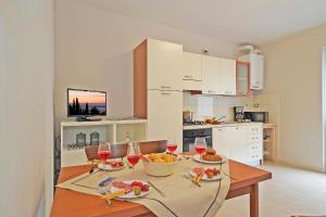 een keuken met een tafel met eten en wijnglazen bij Appartamento Alla Fonte in Salò