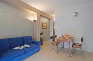 un soggiorno con divano blu e tavolo di Appartamento Alla Fonte a Salò
