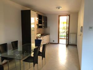 a kitchen with a glass table and black cabinets at Trilocale in villetta piano terra indipendente in Osio Sotto