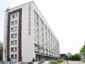 a white building with a red sign on it at Voznesenskaya Hotel in Ivanovo