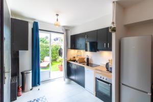 a kitchen with blue cabinets and a refrigerator at Le Coin de Marie à deux pas du centre ville in Rambouillet