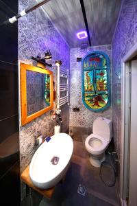 uma casa de banho com um lavatório, um WC e uma janela. em Apart Hotel Qetostan em Tbilisi