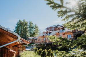 a log cabin building with trees in the foreground at Résidence Sunêlia Les Logis d'Orres in Les Orres