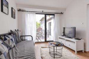 ein Wohnzimmer mit einem Sofa und einem TV in der Unterkunft • Minimalism & Charisma • in Sofia's top centre • in Sofia