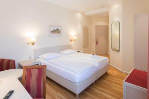 ein Schlafzimmer mit einem großen weißen Bett in einem Zimmer in der Unterkunft martas Hotel Albrechtshof Berlin in Berlin
