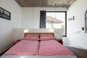 una camera con letto con lenzuola a quadri rosse e bianche di Cologne Country Lodge a Colonia