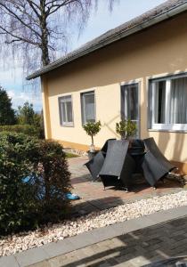 a house with two black tables in front of it at Ferienwohnung Rombachs Spatzennest in Herbolzheim
