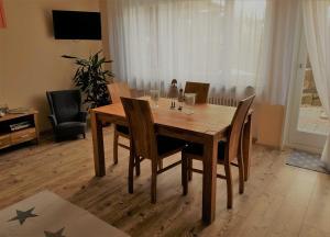 a wooden dining room table and chairs in a living room at Ferienwohnung Rombachs Spatzennest in Herbolzheim