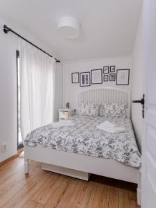 ein weißes Schlafzimmer mit einem großen Bett und Holzboden in der Unterkunft • Minimalism & Charisma • in Sofia's top centre • in Sofia