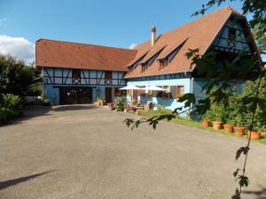 a large white building with a red roof at Le Gîte bleu in Willgottheim